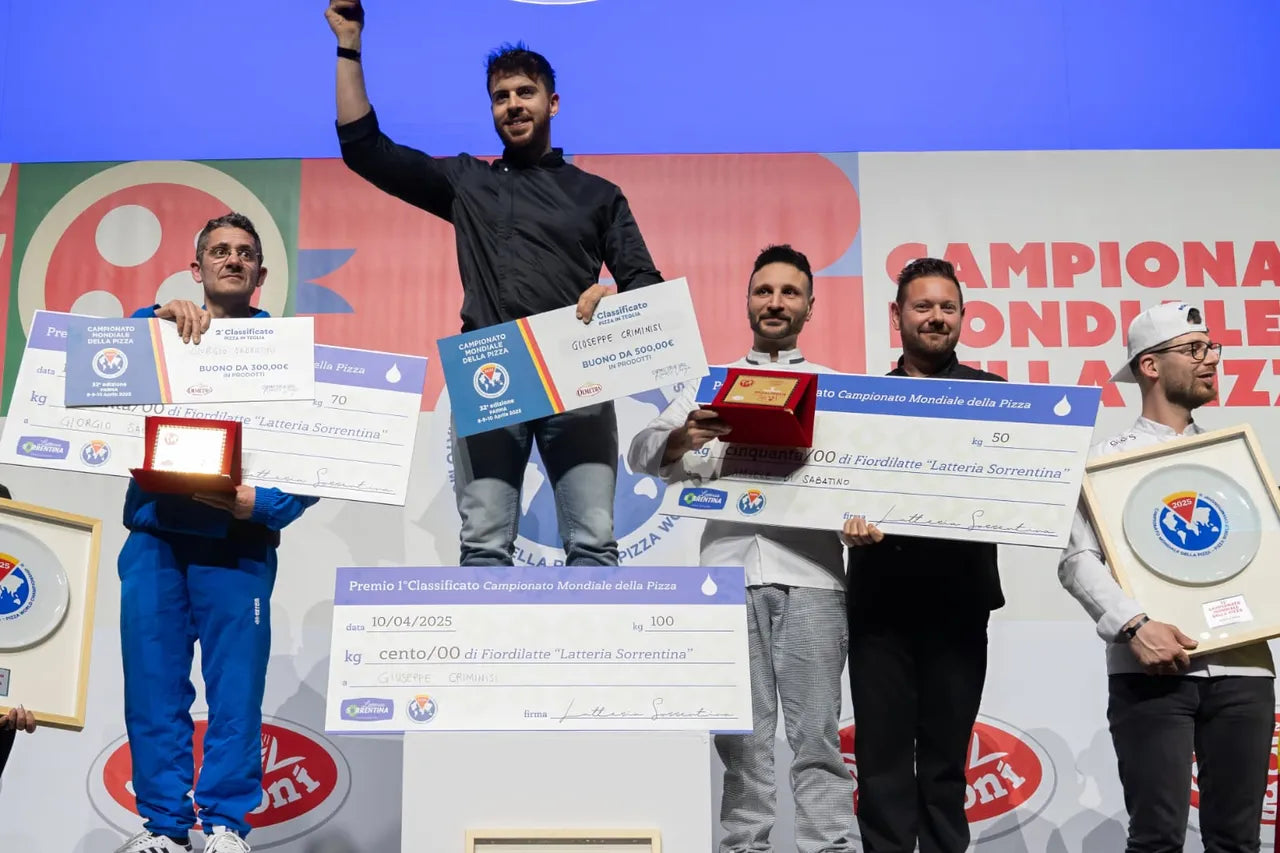 Podium du Championnat Mondial de la Pizza 2025 avec les lauréats, dont Giuseppe Criminisi au centre tenant un chèque géant et un trophée