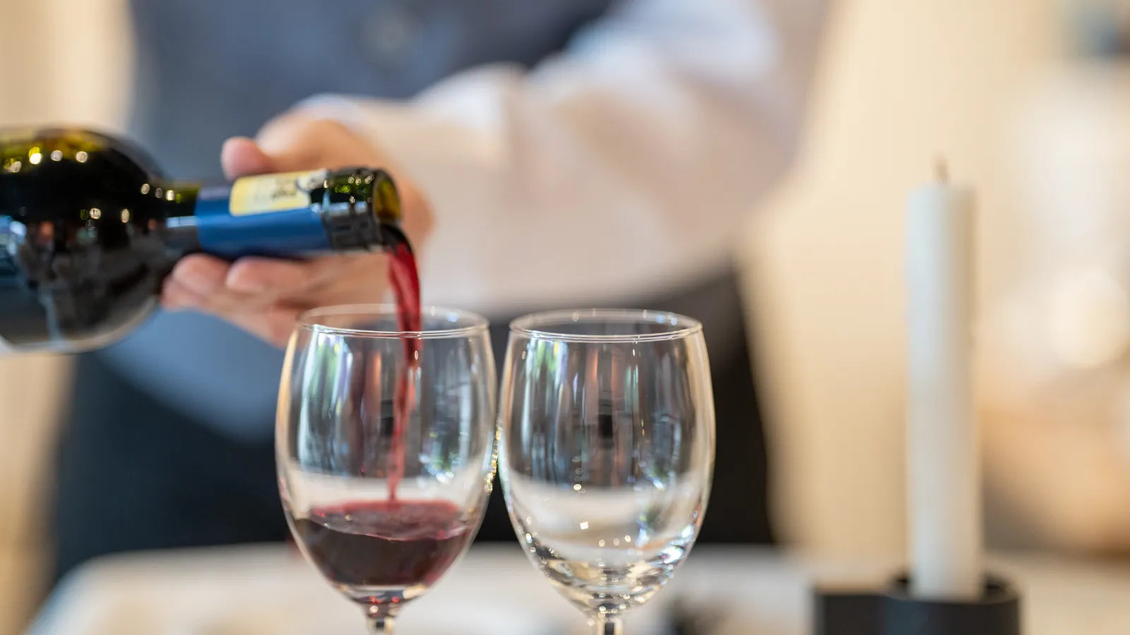 Sommelier versant un verre de vin rouge au restaurant