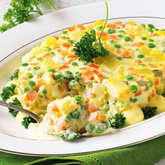  Insalata russa classique servie dans un bol décoré avec de la mayonnaise.