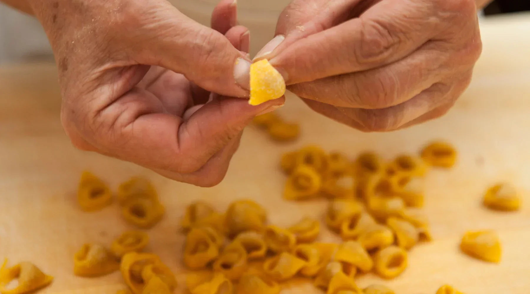 Main d'une membre du projet façonnant un tortellino traditionnel à Modène.