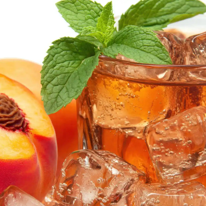 Boisson Estathé Pêche servie avec glaçons et tranches de pêche, thé glacé italien rafraîchissant.