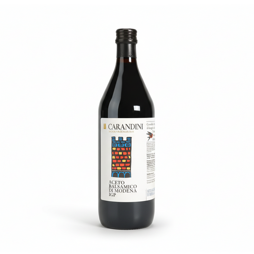 Bouteille en verre foncé bordelaise d'Aceto Balsamico di Modena IGP de la maison Carandini, fondée en 1860 à Modène, Italie — étiquette blanche illustrée de barriques traditionnelles en rouge, jaune et bleu, symbole du processus d'affinage en fûts de bois.