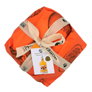 Panettone artisanal Arancino 32° avec liqueur à l’orange Morelli, emballé dans un papier orange avec ruban. Panettone à la liqueur.
